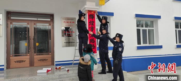 圖為恩和哈達邊境派出所民警貼對聯(lián)?！《骱凸_邊境派出所供圖